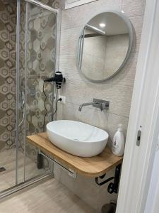 ein Badezimmer mit einem weißen Waschbecken und einem Spiegel in der Unterkunft Metro Stazione-Museo 500 m-Appartamento Centrale ed Elegante Dimora De Curtis in Neapel