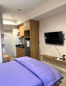a bedroom with a purple bed and a flat screen tv at Property 2A in Pekayon Satu