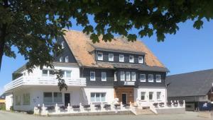 ein großes weißes Haus mit braunem Dach in der Unterkunft Die zwei Löwen Ferienwohnungen in Winterberg