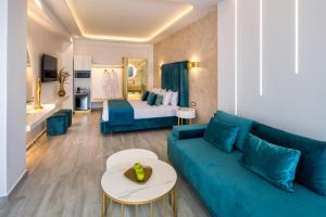 salon z niebieską kanapą i łóżkiem w obiekcie Aura Suites w mieście Firostefani
