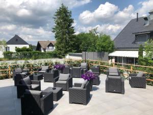 - un ensemble de chaises sur une terrasse avec des fleurs violettes dans l'établissement Die zwei Löwen Ferienwohnungen, à Winterberg