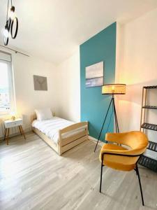 a bedroom with a bed and a chair in it at Etretat au Coeur in Étretat +1 photo