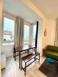 a living room with a table and a green couch at Etretat au Coeur in Étretat