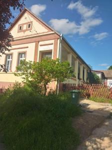 a house with a tree in front of it at Kiskassa Vendégház 