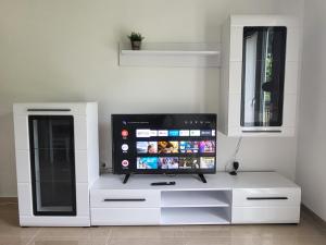 un centro di intrattenimento bianco con TV a schermo piatto di Novi Relax apartment a Herceg-Novi