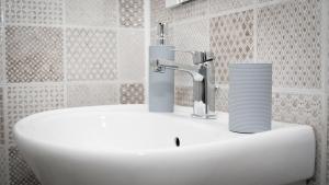 a bathroom sink with two cups on top of it at Casa Calina in Călimăneşti +51 photos