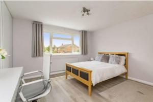 a bedroom with a bed and a desk and a chair at Spacious 5 Bedroom 11 Guest Family House in Horsham in Roffey