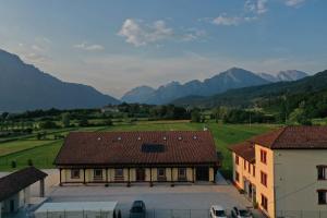 a view of a building with mountains in the background at AGRITURISMO MODOLO Belluno Dolomiti in Belluno