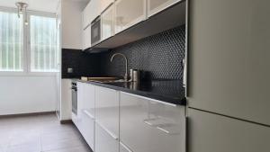 a kitchen with white cabinets and a sink at Jardines de Banús Apartments in Marbella