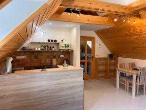 - une cuisine avec un comptoir et une table dans une pièce dans l'établissement HOFBERG Apartmán, à Nové Hamry