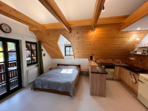 een slaapkamer met een bed in een kamer met houten wanden bij HOFBERG Apartmán in Nové Hamry