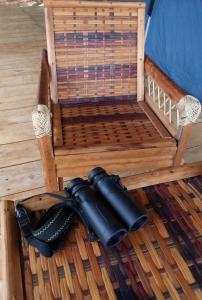 un parasol noir assis au-dessus d'une chaise en bois dans l'établissement Glamping Lakeview Ouidah, 
