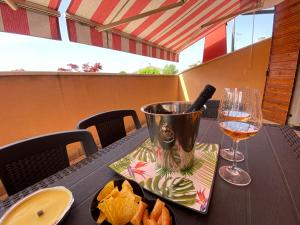 a table with a glass of wine and a plate of chips at Casa Fanny in Castelnuovo del Garda