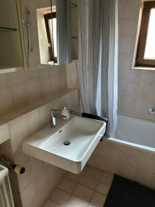 a bathroom with a sink and a tub and a mirror at Wohnung in Landshuter Altstadt in Landshut