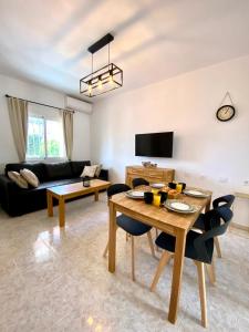 a living room with a table and a couch at Olive Tree Bungalow La Zenia in Orihuela Costa