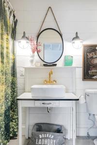 uma casa de banho com um lavatório e um espelho em Hip, Cozy Cottage with a Fire Pit in Cleveland Park em Nashville