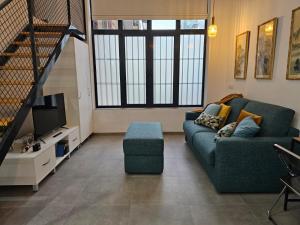 a living room with a couch and a tv at Jardín Viveros-Turia 6 PAX-WIFI Y PARKING GRATIS in Valencia