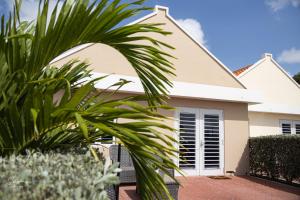 una casa con una palmera delante de ella en Dushi Townhouse Curaçao en Willemstad