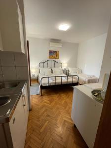 a room with two beds in a room with a kitchen at Studio apartment with swimming pool in Jelsa