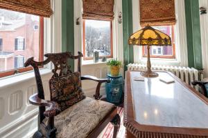 una habitación con una silla y una mesa con una lámpara en The Dolon House Bed & Breakfast! en Jim Thorpe