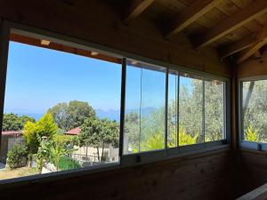 a room with windows with a view of trees at Faralya Villa in Fethiye