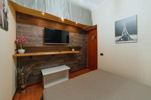 a bedroom with a wooden accent wall with a tv at la terrazza nel centro in Naples