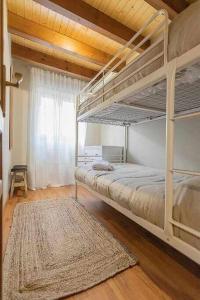 1 dormitorio con 2 literas y alfombra en Casa Cubero - tucasaenlospirineos en Sallent de Gállego