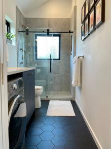 een badkamer met een douche, een toilet en een raam bij Greenwood Getaway in Seattle