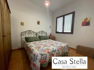 a bedroom with a bed with a floral bedspread at Casa Stella San Vito Lo Capo in San Vito lo Capo