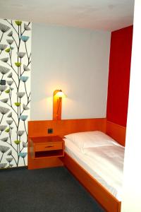 1 dormitorio con 1 cama y 1 mesa con lámpara en Hotel Cafe Lieb, en Bamberg