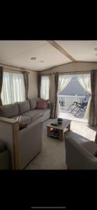 a living room with a couch and a table at Meadows 3 NEW BEACH HOLIDAY PARK in Dymchurch