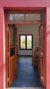 Los MollesにあるCon vista a las sierras, Villa Las Rosas, Traslasierras, Cordobaのデスクと窓のある部屋への開放ドア