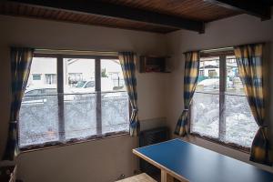 Habitación con 2 ventanas y una mesa azul. en Holger sofus en Ushuaia