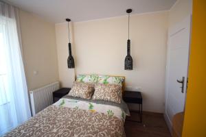 a bedroom with a bed and two pendant lights at Apartamenty Morze Plażowa 4A i 4B in Sarbinowo