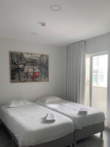 a bedroom with a bed and a picture of a bike on the wall at Bike Suite in Figueira da Foz