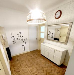 a bathroom with a mirror and a dresser and a clock at Memo Moscavide Guest House in Lisbon +78 photos