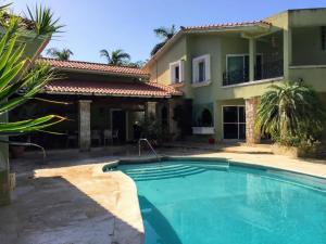 una villa con piscina di fronte a una casa di Casa Beard, Spacious Guest House with High Speed WiFi & Pool. a Playa del Carmen