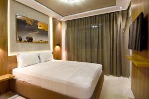 - une chambre avec un grand lit blanc et une fenêtre dans l'établissement Tanger app hotel chambers, à Tanger