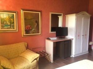 a living room with a couch and a tv at Hotel Bolero in Sirmione