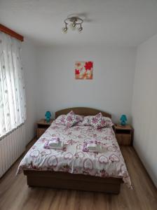 a bedroom with a bed with a pink comforter at Apartment Sanja in Smoljanac