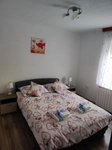 a bedroom with a bed with a pink bedspread at Apartment Sanja in Smoljanac