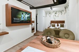 un soggiorno con TV, divano e letto di Sabbia Mini Pool Suites a Preveza