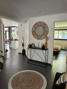 een woonkamer met een tafel en een spiegel bij Grand appartement de 119m2 avec jardin de 219m2 in Quimper