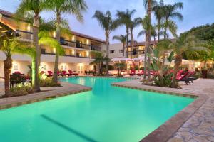 a resort pool with palm trees and chairs at Atrium Hotel Orange County in Irvine