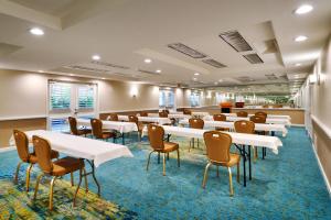 una sala de conferencias con mesas y sillas blancas en Atrium Hotel Orange County, en Irvine