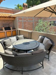 a patio with a table and some chairs and a couch at Doña Jose Suite & Apartments in San Miguel de Allende