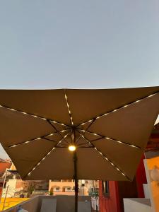 duży brązowy parasol z oświetleniem na balkonie w obiekcie Doña Jose Suite & Apartments w mieście San Miguel de Allende