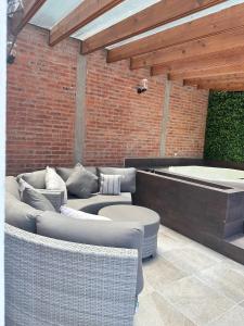 a patio with wicker furniture and a bath tub at Doña Jose Suite & Apartments in San Miguel de Allende