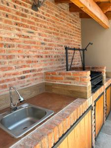 - une cuisine avec un évier et un mur en briques dans l'établissement Doña Jose Suite & Apartments, à San Miguel de Allende