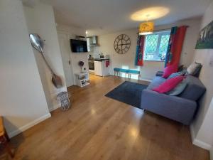 ein Wohnzimmer mit einem blauen Sofa und einem Tisch in der Unterkunft Eastfield cottages in Devizes